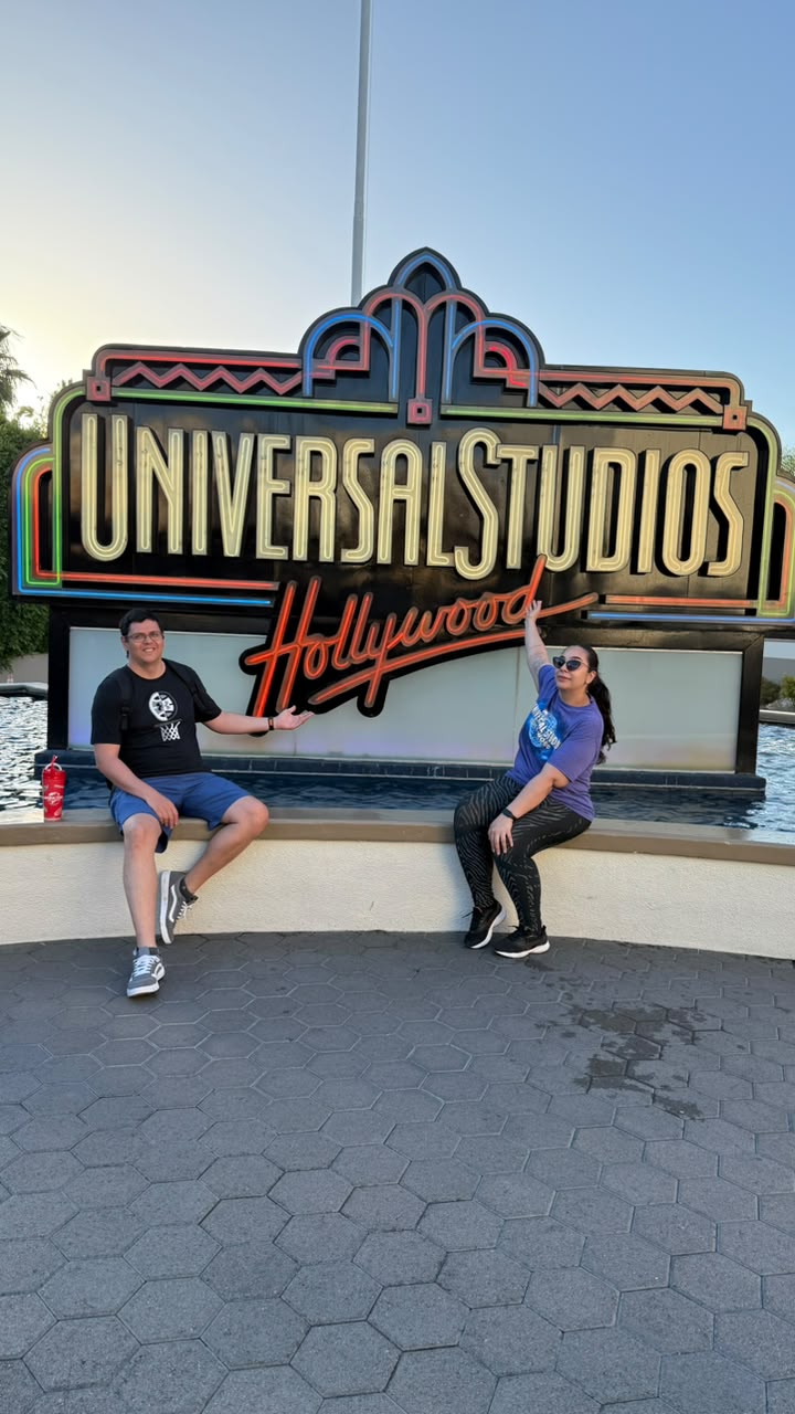 Casal em frente à placa Universal Studios Hollywood